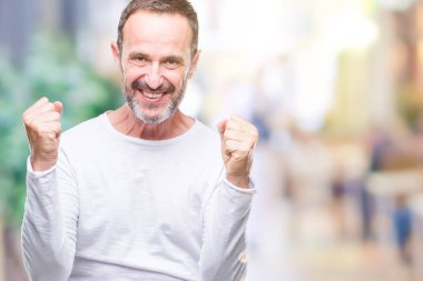 Orta yaş ağarmış komuta sizde izole arka plan kutlama üzerinde beyaz t-shirt giyen şaşırttı ve silah ile başarı için yükseltilmiş ve açık gözler hayrete düşürdü. Kazanan kavramı.