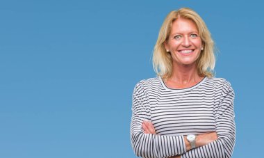 Orta yaş sarışın kadın izole arka plan mutlu yüz çapraz silah kameraya bakarak ile gülümseyen yüzünden. Olumlu bir kişi.