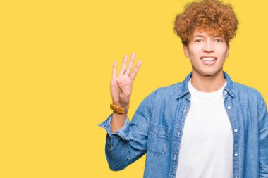 Gösterilen ve parmakları ile işaret denim ceket giyen afro saçlı Genç yakışıklı adam kendinden emin ve mutlu gülümseyerek süre dört numara.