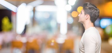 Yakışıklı delikanlı izole arka tarafına, seyir üzerinde dinlenmek doğal yüz emin gülümseme ile pozuyla profili.