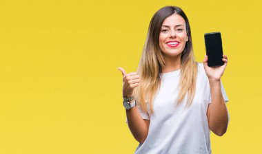 Genç güzel kadın gösteren boş ekran smartphone işaret ve başparmak kadar mutlu yüz gülümseyen tarafı ile gösteren izole arka plan üzerinde