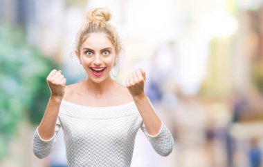 Kadın kutluyor izole arka plan üzerinde şaşırttı ve başarı için kaldırdı kollarını açarak hayret ve gözleri açık genç güzel sarışın ve mavi gözler. Kazanan kavramı.