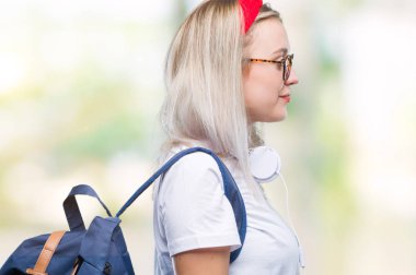 Gözlük ve sırt çantası izole arka tarafına, seyir üzerinde giyen genç sarışın öğrenci kadın dinlenmek doğal yüz emin gülümseme ile pozuyla profili.