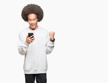Gurur çığlık ve zafer ve başarı çok heyecanlı, kutlama bir smartphone kullanarak afro saçlı genç Afro-Amerikan adam duygu tezahürat