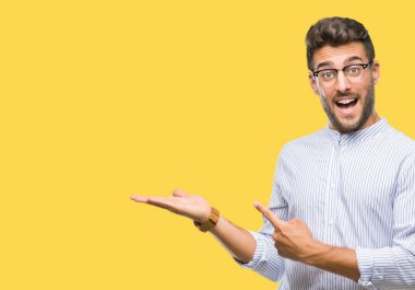 Yakışıklı delikanlı üzerinden hayran ve el ile sunulması ve parmak ile işaret ederken kameraya gülümseyen izole arka plan.