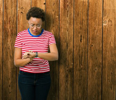 Güzel genç Afro-Amerikan kadın gözlük üzerinde arka izole seyretmek zaman endişeli, geç korkuyor arıyorsunuz