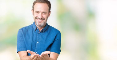 Yakışıklı orta yaş zarif üst düzey adam izole alma veya jest vererek birlikte el avuç içi ile gülen arka plan. Ayrı tutma ve koruma