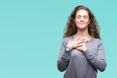 Güzel esmer kıvırcık saçlı Genç kız üzerinde gülümseyen izole arka plan ile bir kazak giyen kapalı gözler ve yüzünde minnettar jest ile göğüs üzerinde eller. Sağlık kavramı.