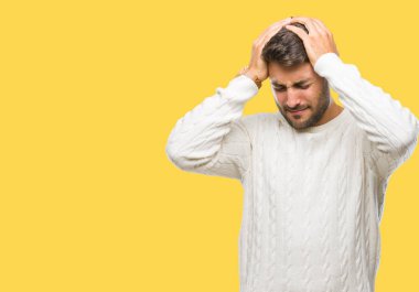 Genç yakışıklı adam giyen kış kazak çünkü umutsuz ve stresli baş ağrısı acı izole arka plan üzerinde ağrı ve migren. Ellerini kafasına.