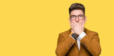 Hata için ellerle ağız kapsayan şok gözlüklü genç yakışıklı iş adamı. Gizli kavramı.