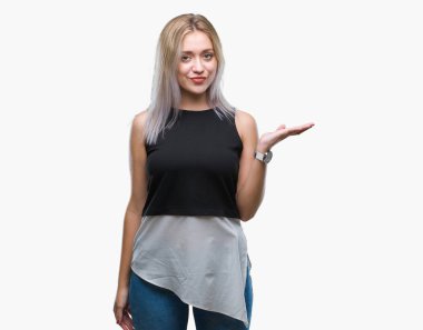 Sarışın genç kadın neşeli sunulması ve kameraya bakarak avucunun ile işaret gülümseyen izole arka plan üzerinde.