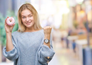 Duygu tezahürat genç kafkas kadın gurur çığlık ve zafer ve başarı çok heyecanlı, kutluyor izole arka plan üzerinde tatlı çörek yeme