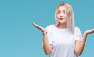 Genç Sarışın kadın yüzünden izole arka plan clueless ve şaşkın bir ifadeyle kollar ve eller kaldırdı. Şüphe kavramı.