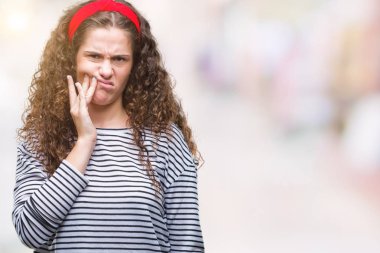 Güzel esmer kıvırcık saçlı Genç kız acı ifadesi ile el ile ağız diş ağrısı veya dişlerde dişlerle ilgili hastalık nedeniyle dokunmadan izole arka plan üzerinde çizgili kazak giyiyor. Diş hekimi kavramı.