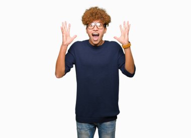 Yakışıklı delikanlı ile deli kutluyor gözlük takan ve silah ile başarı için heyecanlı çığlık kaldırdı ve açık gözleri hayret afro. Kazanan kavramı