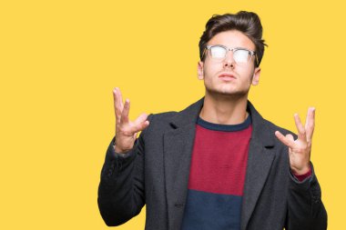 Genç yakışıklı zarif adam gözlüklü üzerinde arka plan deli izole ve deli bağırarak ve agresif ifade ve silah kaldırdı bağırıyor. Hayal kırıklığı kavramı.