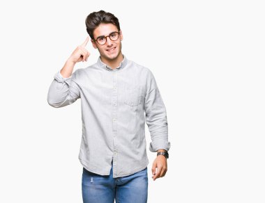 Genç yakışıklı adam gözlük izole üzerinde bir parmak, harika bir fikir ya da düşünce, iyi hafıza ile baş gösteren gülen arka plan