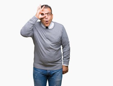 Sürpriz yüz, göz parmaklarının arasından seyir ile orta yaş bussines Arap adam gözlüklü ok jest yapıyor izole arka plan üzerinde şok. İmansız ifade.