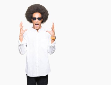 Kızgın ve silah ile başarı için deli kutluyor güneş gözlüğü takıyor afro saçlı genç Afro-Amerikan adam kaldırdı ve heyecanlı çığlık gözler kapalı. Kazanan kavramı