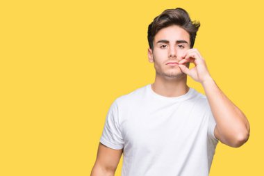 Arka plan ağız beyaz t-shirt üzerinde giyen genç yakışıklı adam izole ve parmak ile ZIP olarak Dudaklarını kapa. Gizli ve sessiz, tabu söz