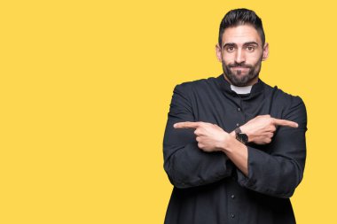 Genç Hıristiyan rahip izole üzerinde arka plan için her iki parmak, farklı yönde ile katılmıyorum işaretleme