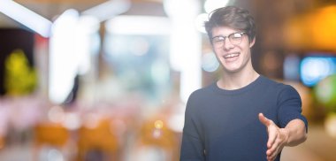 Tebrik ve davet edici dostu sunan karşılıklı gülümseyen izole arka plan üzerinde gözlük takan yakışıklı delikanlı. Başarılı iş.