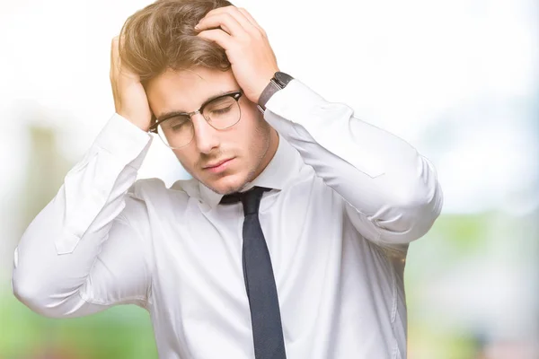年轻的商人戴眼镜在孤立的背景下遭受头痛绝望和压力 因为疼痛和偏头痛 双手放在头上 — 图库照片