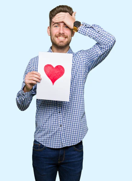 Jovem Homem Bonito Segurando Papel Com Coração Vermelho Estressado Com — Fotografia de Stock