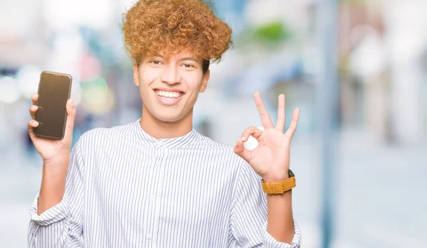 Joven Hombre Guapo Mostrando Pantalla Del Teléfono Inteligente Haciendo Signo —  Fotos de Stock