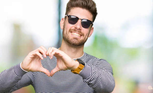 Homem Bonito Jovem Usando Óculos Sol Sorrindo Amor Mostrando Símbolo — Fotografia de Stock