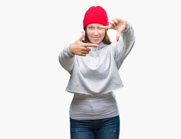 年轻的高加索美丽的女人穿着羊毛帽在孤立的背景微笑的框架与手和手指与快乐的脸 创意和摄影理念 — 图库照片