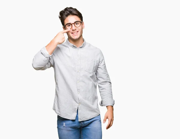 年轻英俊的男人戴着眼镜在孤立的背景指向用手指对脸和鼻子 微笑欢快 — 图库照片