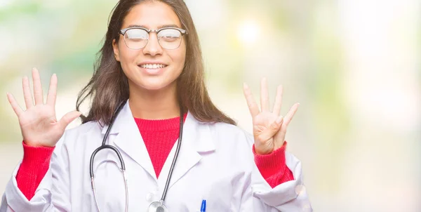 年轻的阿拉伯医生妇女在孤立的背景显示和指向与手指数字九同时微笑自信和快乐 — 图库照片