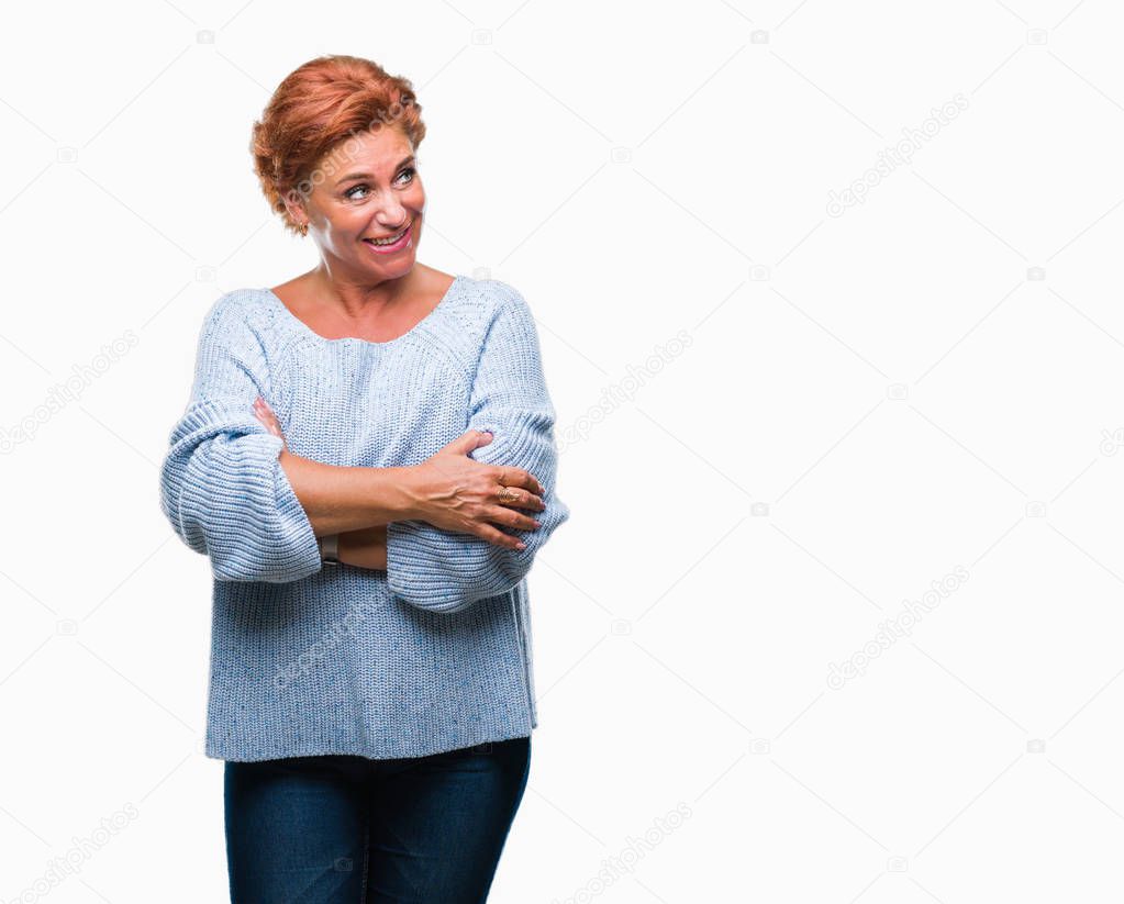 Atrractive senior caucasian redhead woman wearing winter sweater over isolated background smiling looking side and staring away thinking.