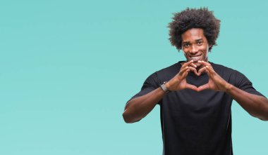 Kalp simgesi ve elleriyle şekil gösterilen aşık gülümseyen izole arka plan üzerinde Afro Amerikalı adam. Romantik kavramı.
