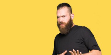 Rahat t-shirt giyen genç sarışın adam tiksinti ifadesi, memnun ve korkulu tiksinti yüz yapıyorsun çünkü nefret tepki. Elleriyle kaldırdı. Sinir bozucu kavramı.