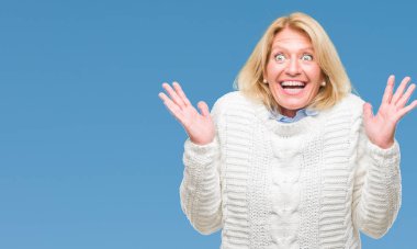 Arka plan deli kutluyor üzerinde kış kazak giyen orta yaş sarışın kadın izole ve crazy arms ile başarı için kaldırdı ve heyecanlı çığlık gözler kapalı. Kazanan kavramı