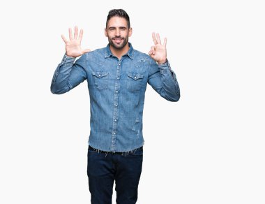 Yakışıklı delikanlı gösterilen ve parmakları ile işaret izole arka plan üzerinde kendinden emin ve mutlu gülümseyerek süre sekiz numara.