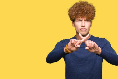 Yakışıklı delikanlı afro saç ret ifade geçiş parmakları eksi işareti yapıyor