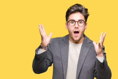 Üzerinde gözlük takan genç iş adamı deli kutluyor arka plan izole ve çığlık kaldırdı ve açık gözleri heyecanlı silah ile başarı için hayrete düşürdü. Kazanan kavramı