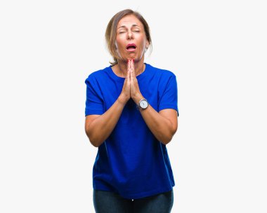 Orta yaş İspanyol kadın kıdemli yalvarıyor ve umut ifade yüzünde çok duygusal ve endişe ile birlikte elleriyle dua izole arka plan üzerinde. Bağışlanmak. Din kavramı.