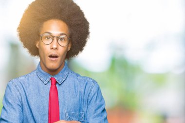 Genç Afro-Amerikan iş adamı afro saç gözlük ve kırmızı kravat korkuyor ve sürpriz ifade ile şok korku ve yüz heyecanlı.