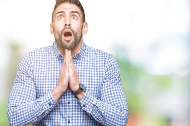 Yakışıklı delikanlı yalvarıyor ve umut ifade yüzünde çok duygusal ve endişe ile birlikte elleriyle dua izole arka plan üzerinde. Bağışlanmak. Din kavramı.