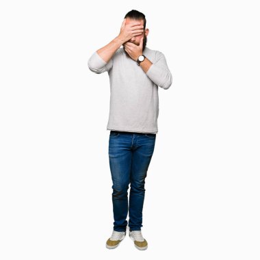 Casual kazak kapsayan gözler ve ağız el ile giyen genç sarışın adam şaşırttı ve şok. Duygu gizleme