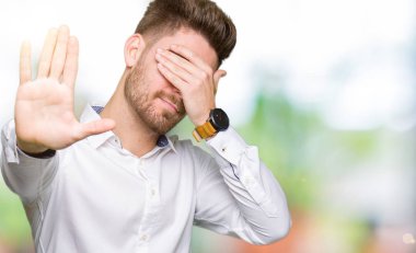 Genç yakışıklı iş adam ellerini gözlerinle kapsayan ve stop jest ile acı ve korku ifadesi. Utandım ve negatif kavramı.