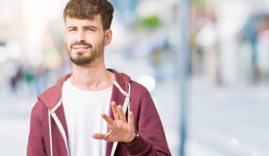 Yakışıklı delikanlı izole arka plan üzerinde tiksinti ifadesi, memnun ve korkulu tiksinti yüz yapıyorsun çünkü nefret tepki. Elleriyle kaldırdı. Sinir bozucu kavramı.