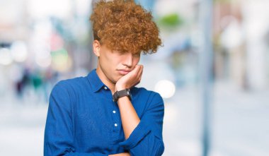 Düşünme afro saç seyir ile genç yakışıklı zarif adam yorgun ve sıkılmış çapraz silah depresyon sorunları ile.