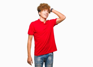 Afro saçlı çekici poz kırmızı t-shirt gülen saç jest, el ile dokunmak emin giyen genç yakışıklı adam