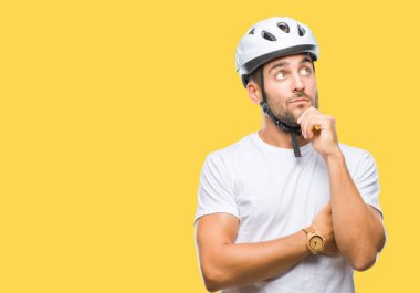 Çene düşünme hakkında soru, dalgın ifade üzerine el ile izole arka plan üzerinde bisikletçi Güvenlik kask giymiş yakışıklı delikanlı. Düşünceli yüzüyle gülümsüyor. Şüphe kavramı.