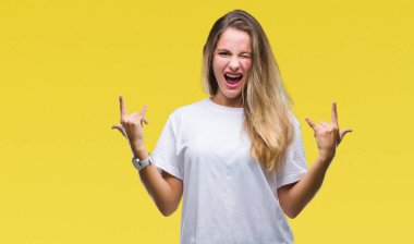 Deli ifade rock simge elle yapıyor ile bağırarak izole arka plan üzerinde rahat beyaz t-shirt giyen genç güzel sarışın kadın. Müzik yıldızı. Ağır kavramı.